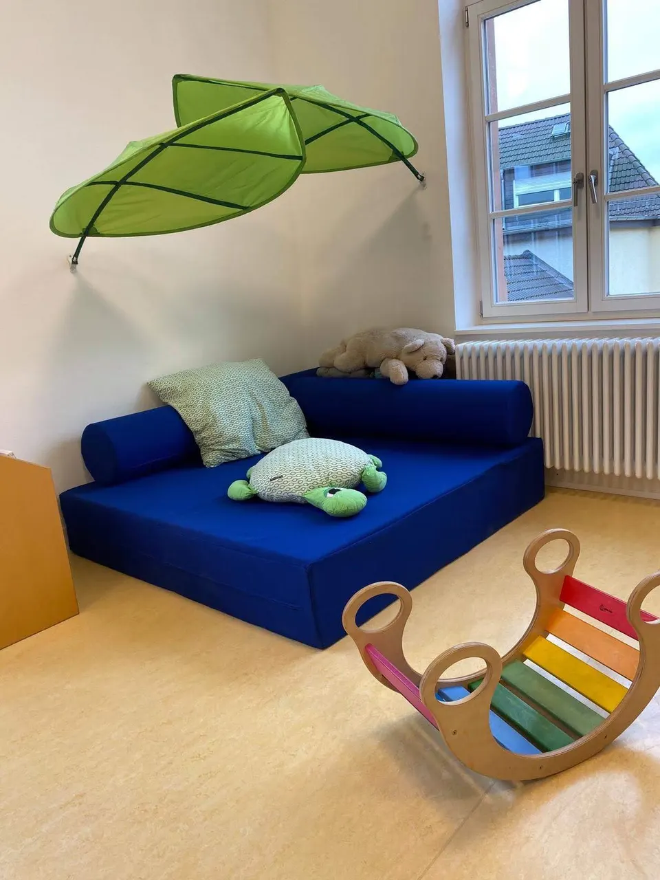 Gemütliche Kuschelecke mit Regenbogenwippe im Minis-Gruppenraum